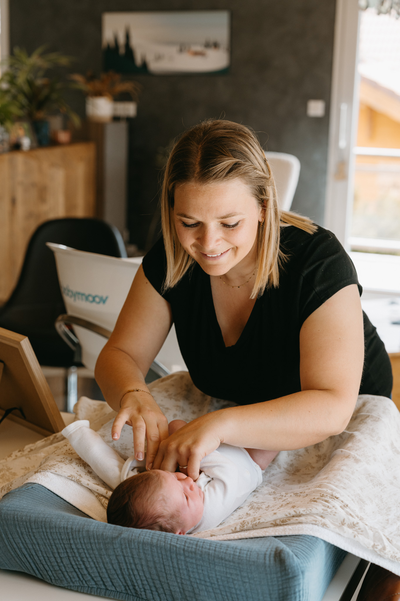 Julie s'occupant d'un bébé allongé sur une table à langer