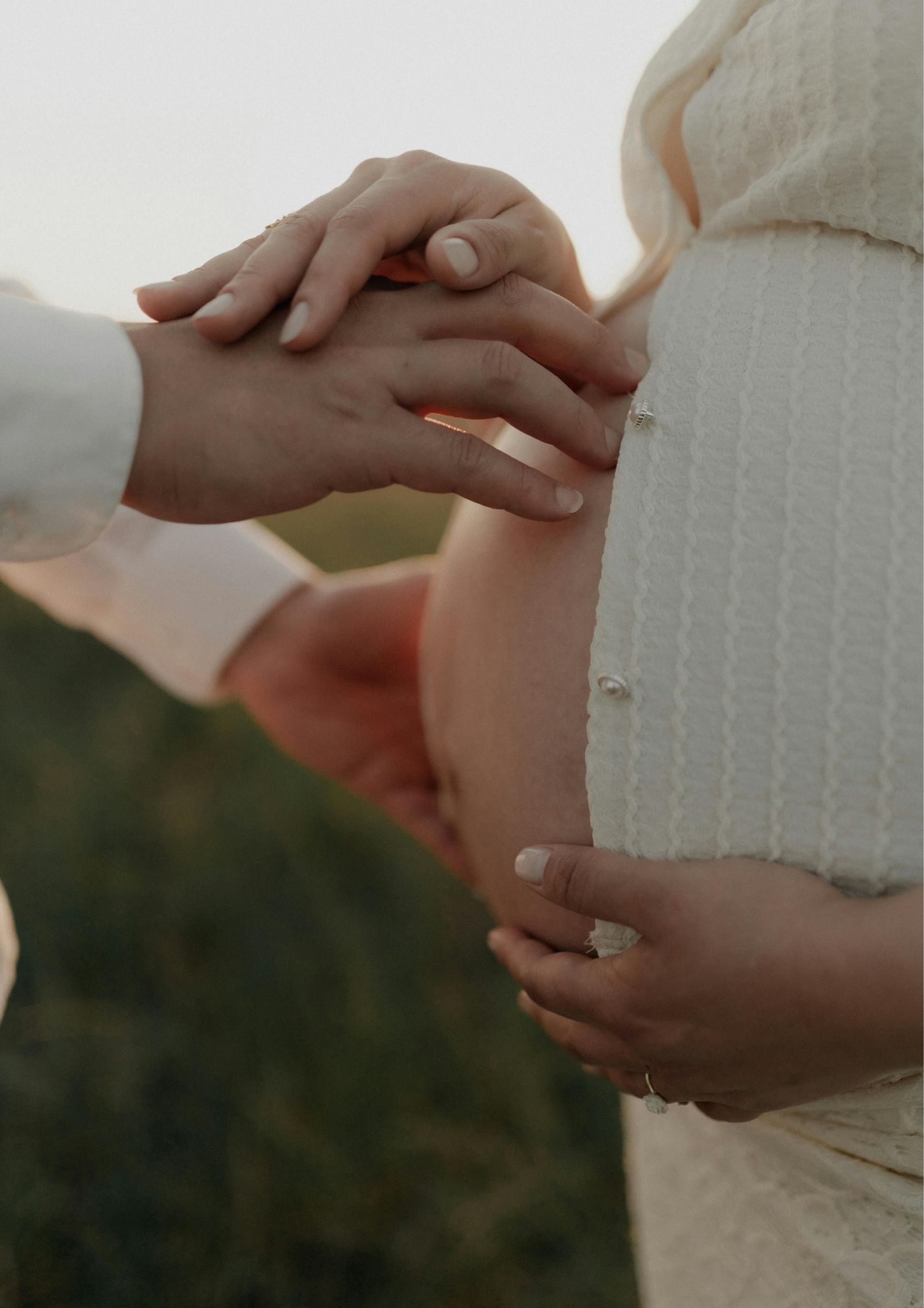 Zoom sur le ventre rond d'une femme enceinte avec ses mains et celles de son conjoint