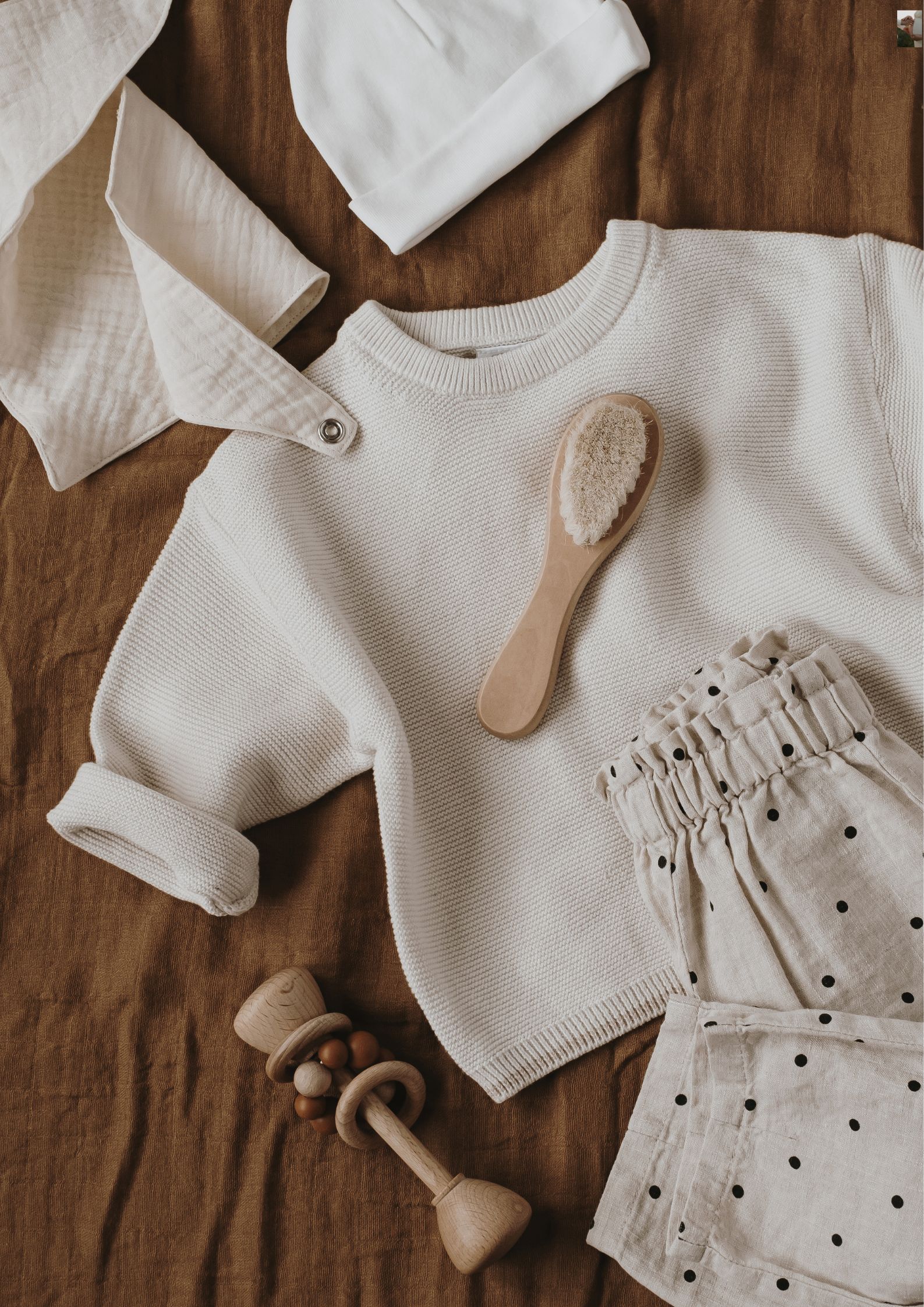 Une tenue de bébé unisexe avec un petit pantalon, un gilet cache coeur, une petite brosse à cheveux et un hochet